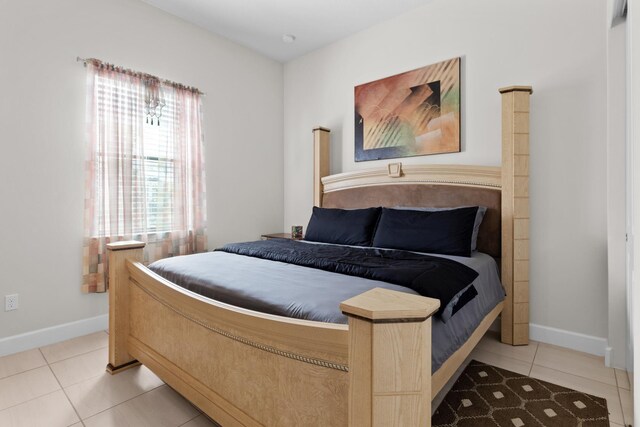 bedroom with light tile patterned flooring and baseboards