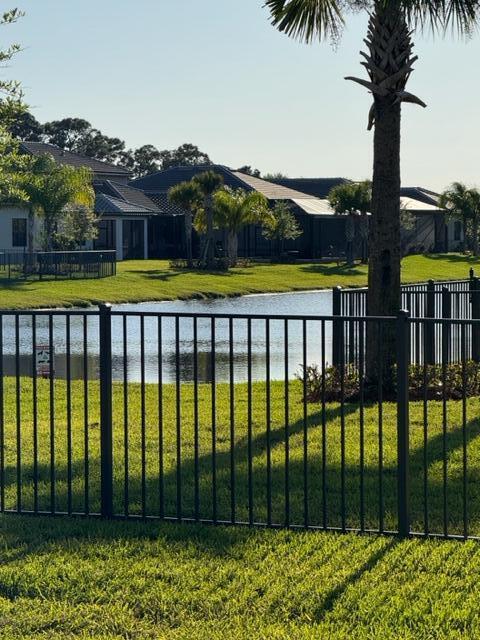 view of yard featuring a water view and fence