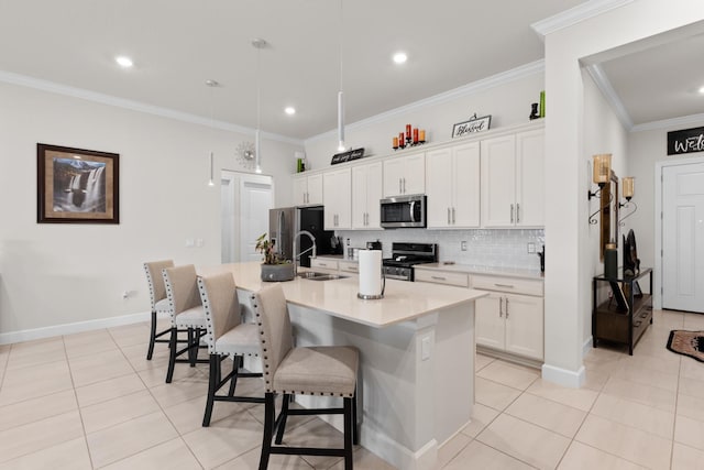 kitchen featuring stainless steel appliances, an island with sink, a sink, a breakfast bar area, and light tile patterned floors