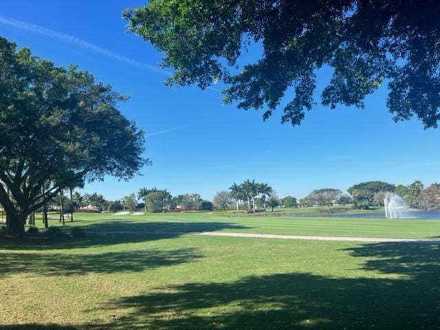 view of community featuring view of golf course and a lawn