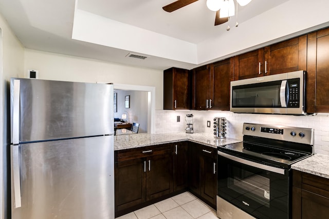 kitchen with tasteful backsplash, visible vents, ceiling fan, light stone countertops, and stainless steel appliances