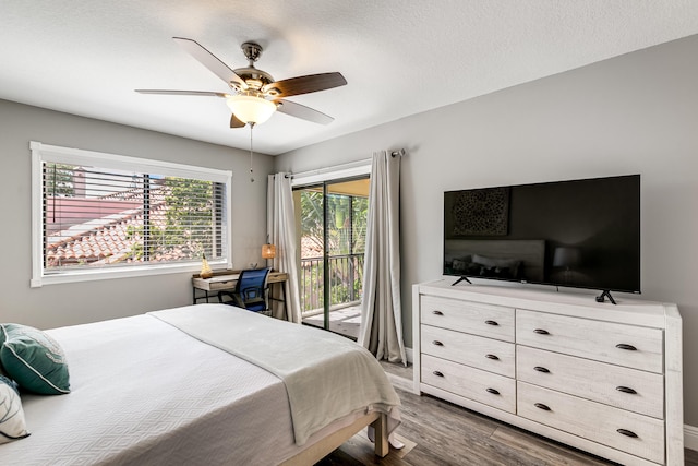 bedroom featuring a textured ceiling, access to outside, wood finished floors, and ceiling fan