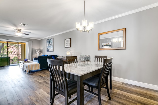 dining space featuring visible vents, baseboards, wood finished floors, and crown molding