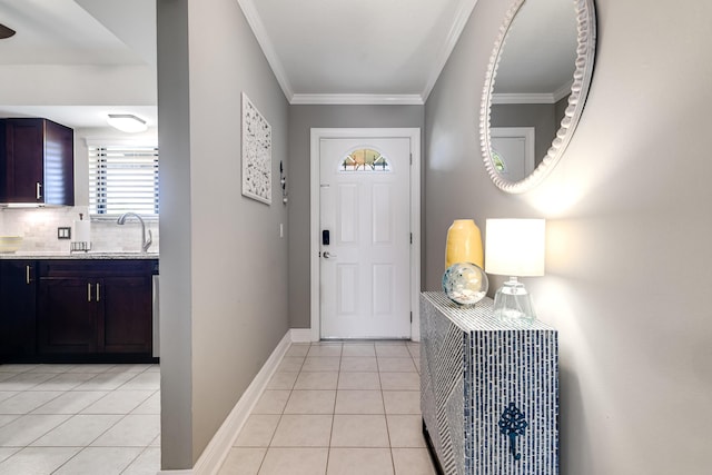 entrance foyer with baseboards, light tile patterned flooring, and ornamental molding