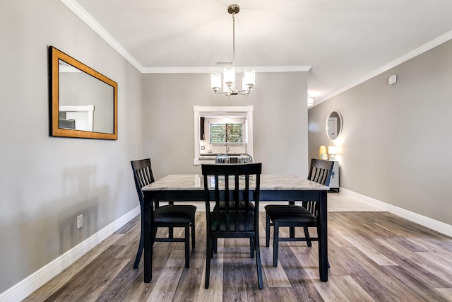 dining area featuring a notable chandelier, baseboards, and ornamental molding