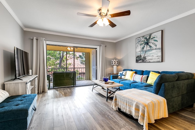 living room with crown molding, a ceiling fan, and wood finished floors