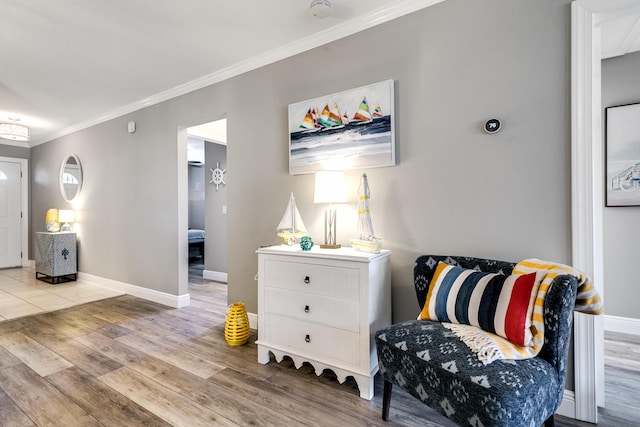 living area featuring ornamental molding, baseboards, and wood finished floors