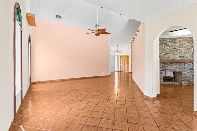 unfurnished living room featuring arched walkways, light tile patterned floors, a ceiling fan, and visible vents