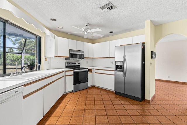 kitchen featuring visible vents, a textured ceiling, a sink, and appliances with stainless steel finishes
