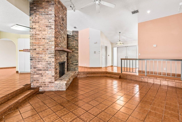unfurnished living room featuring tile patterned flooring, visible vents, and a textured ceiling