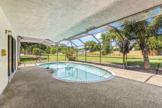 pool featuring a patio area, a yard, and glass enclosure