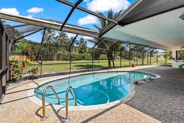 pool with a patio, a yard, and glass enclosure