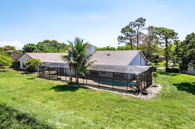 back of property featuring an outdoor pool, glass enclosure, a patio, and a lawn