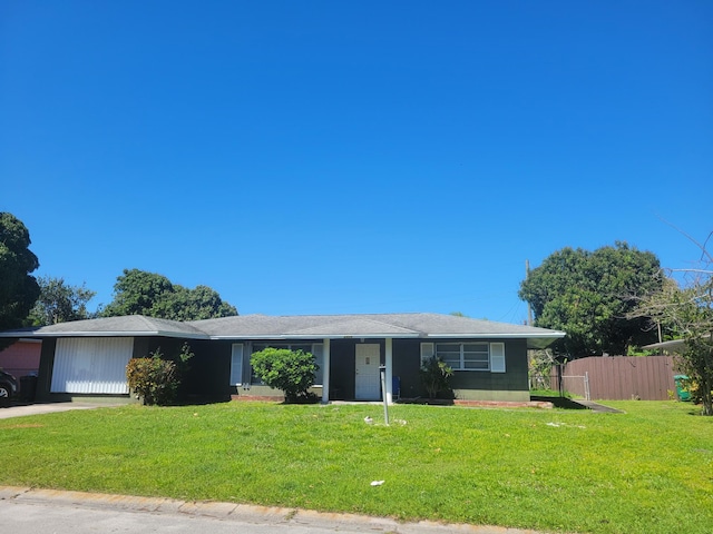 ranch-style home featuring a front yard and fence