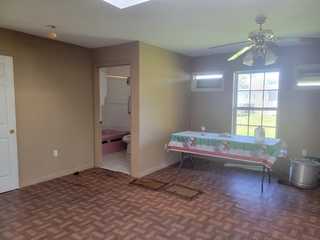 bedroom with ceiling fan, ensuite bathroom, and baseboards