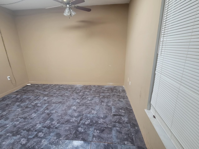 empty room with baseboards and a ceiling fan