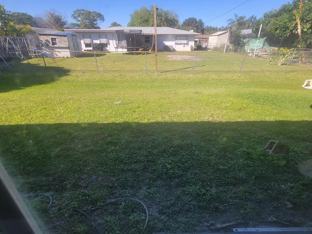 view of yard featuring fence and a sunroom