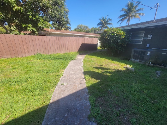 view of yard featuring central air condition unit and fence