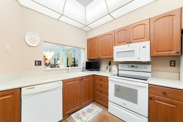 kitchen featuring a sink, white appliances, and light countertops