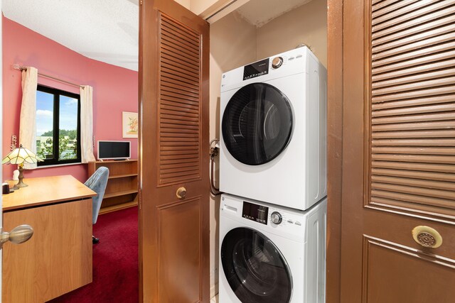 6941 SE Constitution Blvd Unit 101, Hobe Sound, FL 33455 - washroom with stacked washer / drying machine, carpet flooring, and a desk
