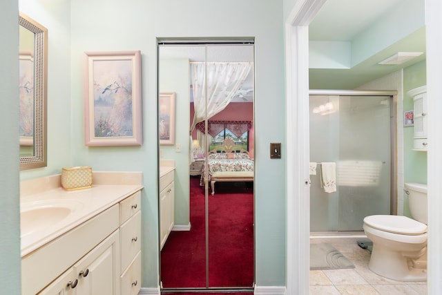 ensuite bathroom with tile patterned floors, toilet, ensuite bathroom, a shower stall, and vanity