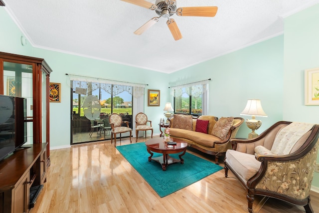 living area featuring ceiling fan, baseboards, wood finished floors, and crown molding