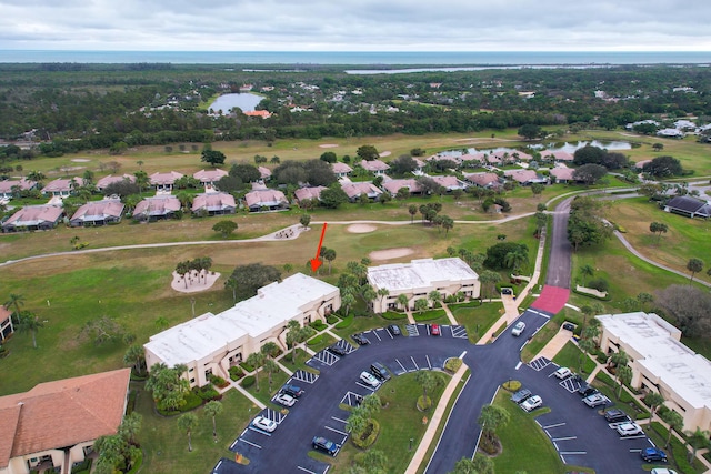 bird's eye view featuring golf course view, a water view, and a residential view