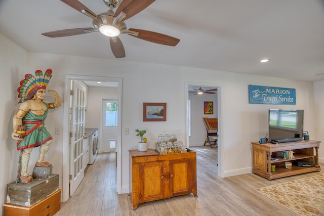 corridor with washer and dryer, french doors, light wood-style flooring, and baseboards