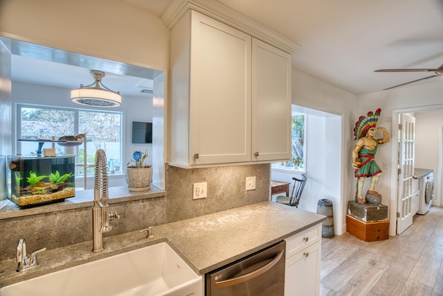 kitchen with a ceiling fan, light wood finished floors, a sink, stainless steel dishwasher, and tasteful backsplash