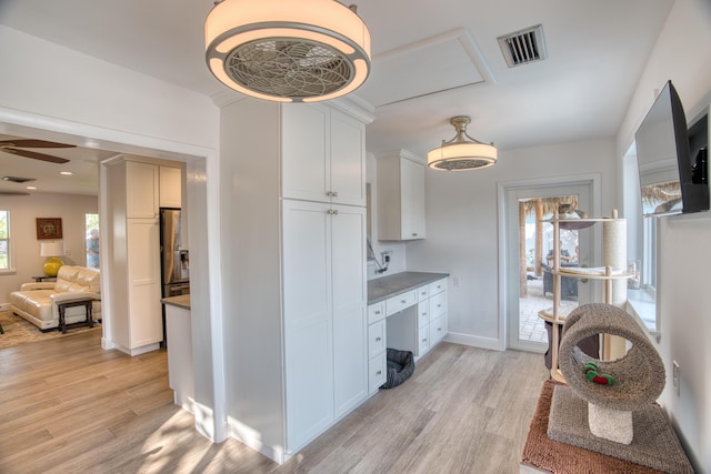 kitchen featuring a ceiling fan, baseboards, visible vents, light wood-style floors, and white cabinetry