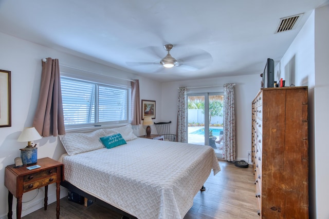 bedroom with visible vents, access to outside, wood finished floors, baseboards, and ceiling fan