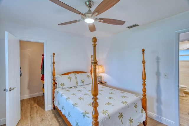 bedroom with visible vents, baseboards, and wood finished floors