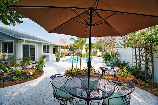 view of patio with outdoor dining area, a fenced backyard, and a fenced in pool