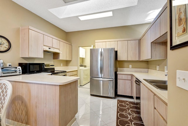 kitchen featuring light brown cabinets, under cabinet range hood, a peninsula, stainless steel appliances, and a sink
