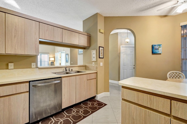 kitchen featuring dishwasher, light countertops, light brown cabinets, and arched walkways