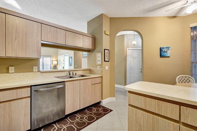 kitchen with dishwasher, light countertops, arched walkways, and light brown cabinetry