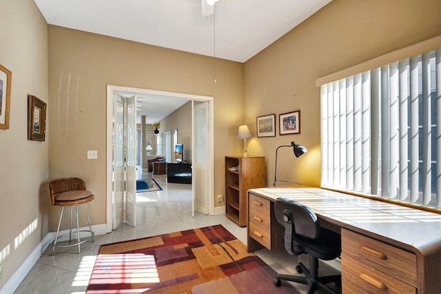 home office featuring light tile patterned floors and baseboards