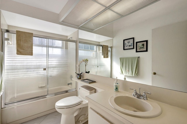 bathroom featuring combined bath / shower with glass door, toilet, and vanity
