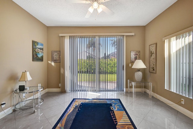 unfurnished room with baseboards, a textured ceiling, and ceiling fan