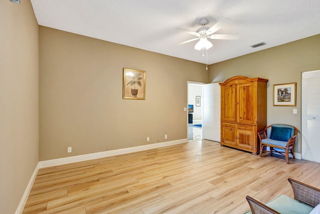 unfurnished room with visible vents, light wood-style flooring, baseboards, and ceiling fan