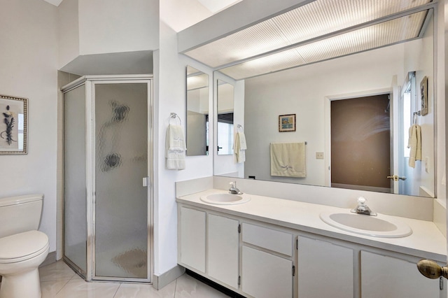 bathroom with a shower stall, toilet, double vanity, and a sink