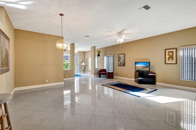 living room with visible vents, baseboards, a textured ceiling, and ceiling fan with notable chandelier