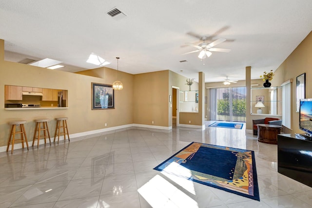 living area with visible vents, baseboards, and ceiling fan with notable chandelier