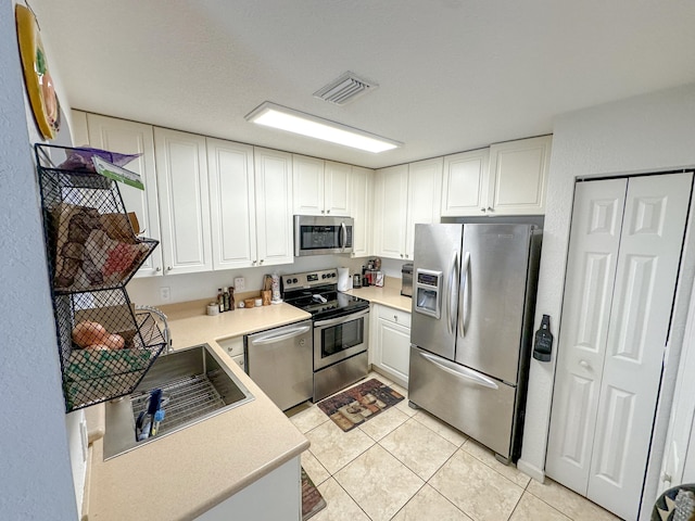 kitchen featuring white cabinetry, light tile patterned floors, visible vents, and stainless steel appliances