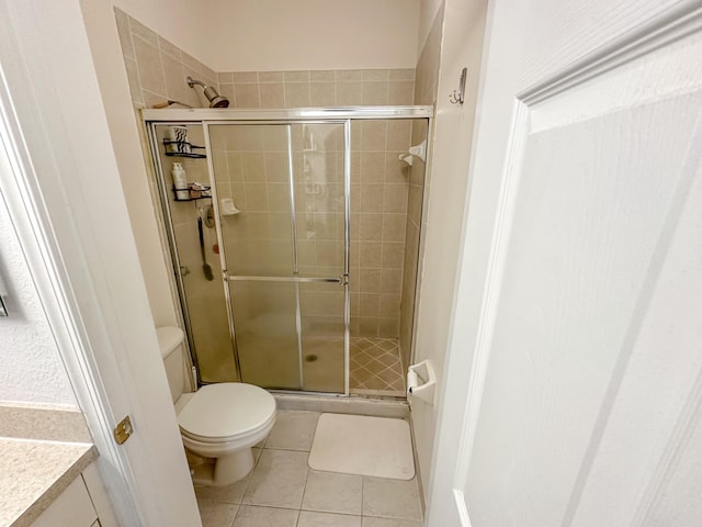 full bathroom featuring tile patterned flooring, a shower stall, and toilet