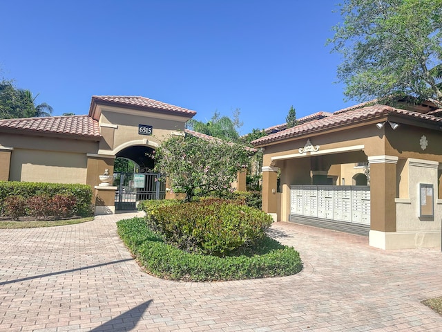 mediterranean / spanish-style home with stucco siding, decorative driveway, and a tiled roof