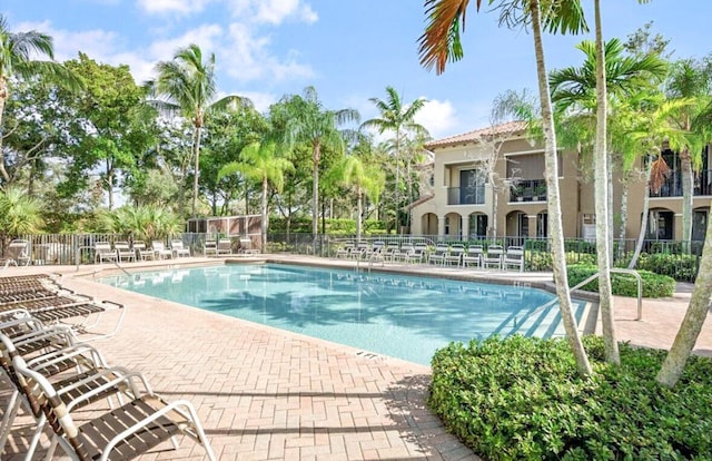 community pool featuring a patio and fence