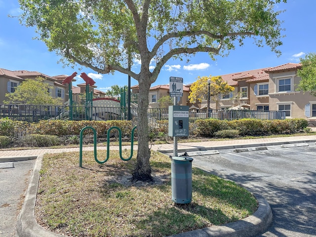 view of community with fence, a residential view, and uncovered parking