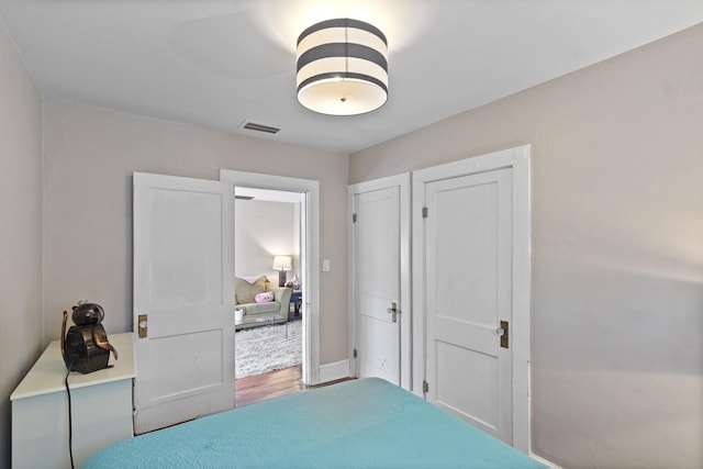 bedroom with visible vents and wood finished floors