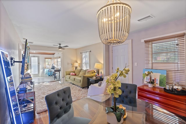 dining room featuring ceiling fan with notable chandelier, wood finished floors, and visible vents